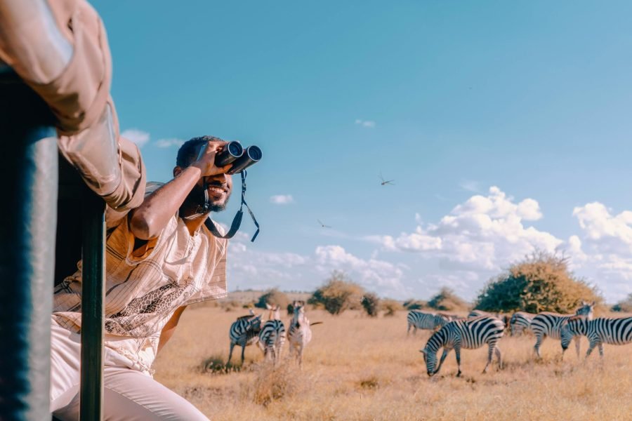 young man with binocular on a safari